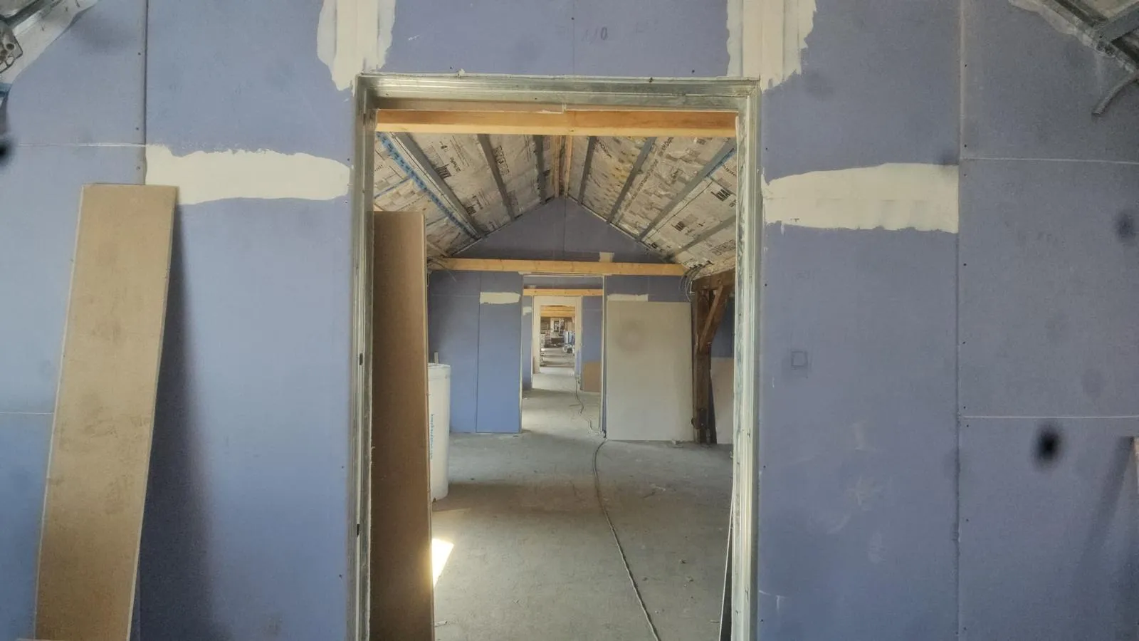 Dachgeschossausbau: neue Trockenbauwand mit Türöffnung, Blick in die nächsten Räume